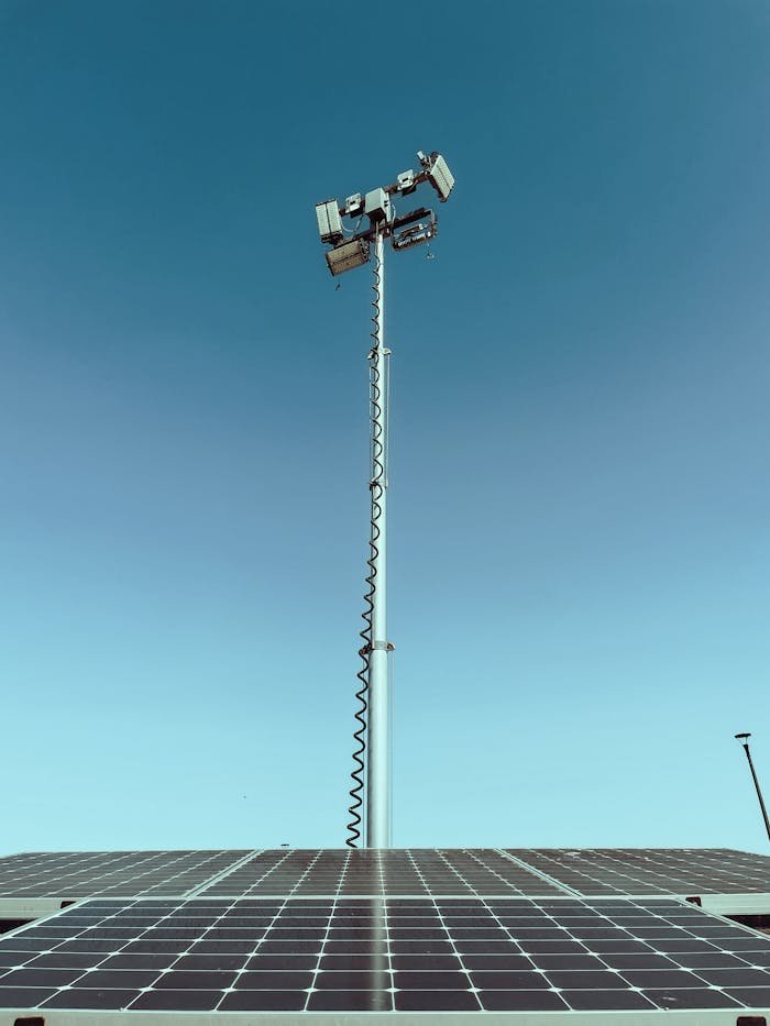 about-03 Solar panel with a light post extending into a clear blue sky, highlighting clean energy.